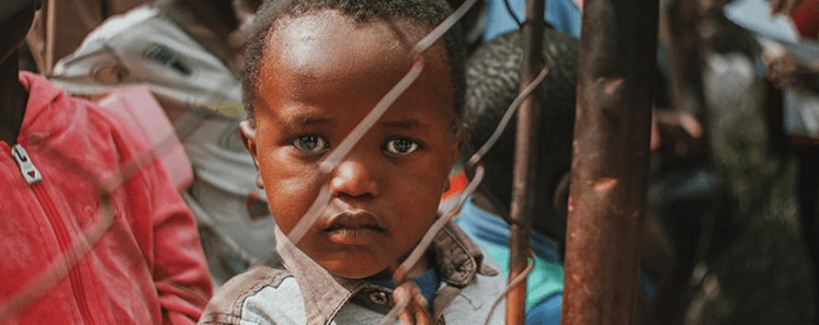 Child smiling at an A'khira Charity sponsored community project